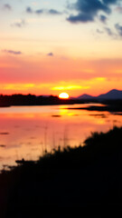 Obraz premium Vibrant Sunset Landscape with Water Reflection vertical