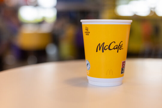 Kerpen, Germany - August, 9, 2025: Yellow McCafe cup on a table in McDonalds interior