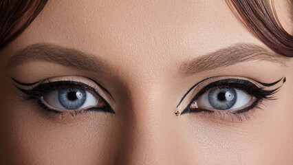 Front view macro photograph of female eyes with striking velvet eyeliner makeup. Glamorous retro...