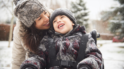 Happy candid mother and disabled child in a wheelchair spending time together in a park playground in the snow. Supportive inclusive family with handicapped children. Inclusion & diversity, Winter