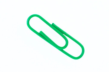 green paper clip on white background