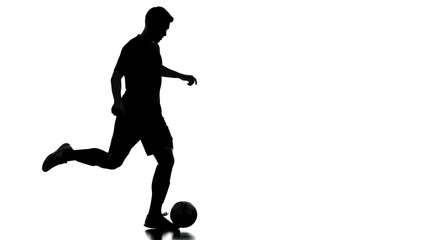 Dynamic silhouette captures a soccer player in full motion about to kick the ball