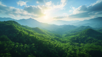 Lush green mountains bathed in the warm glow of a rising sun, creating a serene and majestic landscape.