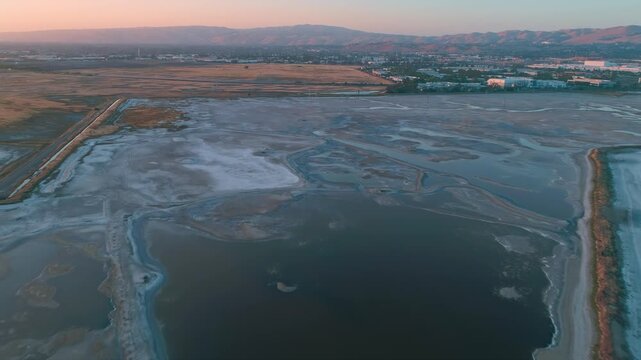 Aerial view of salt ponds in San Francisco Bay Salt Ponds, Fremont, California, USA. The ponds are used for salt production, and the different colors are due to varying salinity levels. 