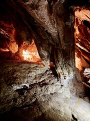 Dramatic rock formations inside a natural cave, lit to reveal intricate textures and layered...