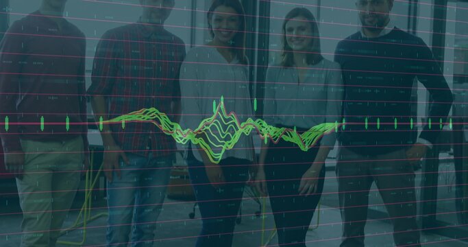 Standing team of professionals reviewing digital chart overlay in workspace, with monitors