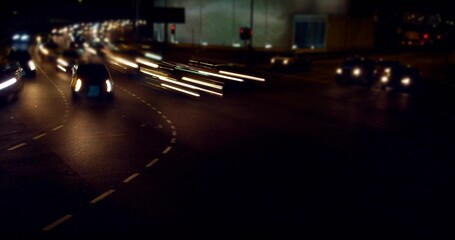 Maneuvering multiple cars through wet urban intersection at night, with glowing light trails