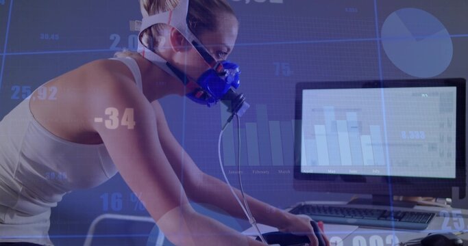 Leaning woman wearing blue mask testing metabolism on bike in lab monitor showing graph, copy space