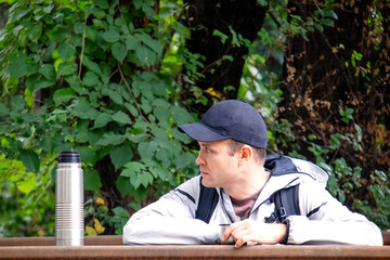 man drinking from a thermos outdoors