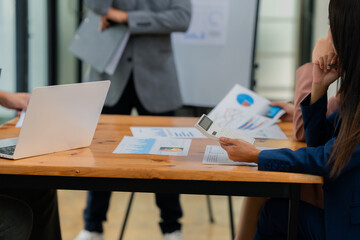 A meeting at the corporate office of business people discussing charts and graphs showing the results of successful teamwork. Close-up of success.