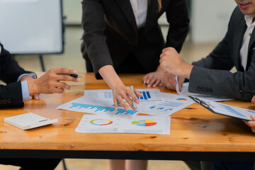 A meeting at the corporate office of business people discussing charts and graphs showing the results of successful teamwork. Close-up of success.