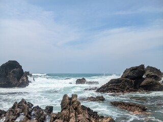 Ocean waves crashing on rocks along the coast.