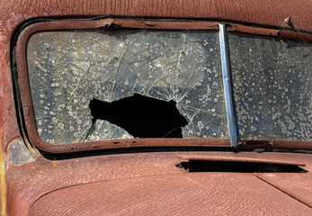 Smashed windshield on a rusted defunct antique truck