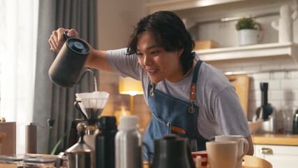 Young Asian man making drip coffee,Grind coffee savor the aroma and flavor at home kitchen in morning vibe,cheerful barista making coffee pouring hot water into dripper,morning lifestyle vibes concept
