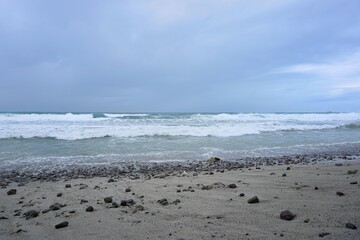Waves on sandy shore of menganti beach indonesia for travel and coastal landscape photography

