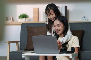 Sisterly bonding over laptop and tablet at home