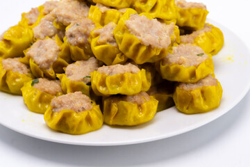 Steaming Hot Siu Mai Dumplings on White Plate, Close-Up View of Traditional Asian Cuisine.