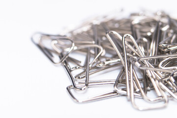 Pile of Silver Paper Clips on White Background, Office Supplies Still Life.