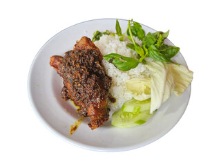 A traditional plate of Indonesian Bebek Madura, a spicy fried duck dish with rich black seasoning,...