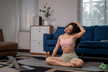 Young asian woman stretching neck doing yoga at home with laptop