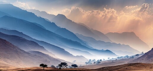 A landscape shows layers of mountain ranges in blue hues, partially veiled in mist under a cloudy sky with beams of light breaking through