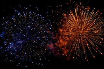 Two vibrant fireworks bursts, blue and orange, against a black night sky