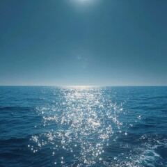 Sun's Glittering Reflection on a Calm Blue Sea Under a Clear Sky