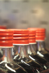 Soda bottles lined up with vibrant red caps close up