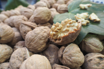 Walnuts displayed with shells and meat at a market