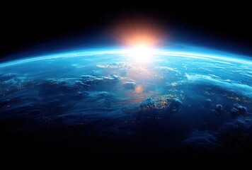 Dramatic image of Earth from space featuring a glowing sunrise breaking over the horizon casting a warm light on clouds and land masses