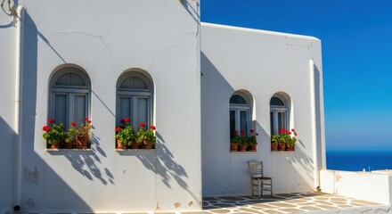 White Mediterranean Building with Arched Windows and Flower Pots on Bright Sunny Day