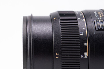 Close-up of a Black Camera Lens with Focus and Zoom Rings on White Background.
