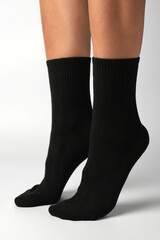 Woman's legs in black athletic socks on a white background
