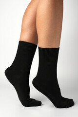 Woman's legs in black athletic socks on a white background