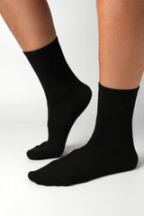 Woman's legs in black athletic socks on a white background