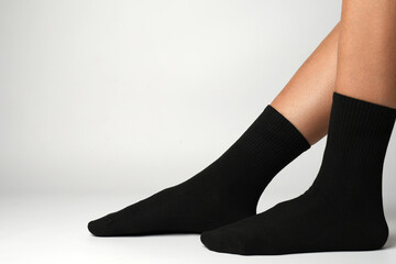 Woman's legs in black athletic socks on a white background