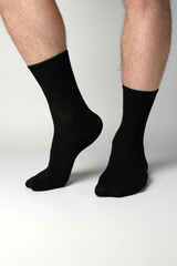 Man's legs in black athletic socks on a white background