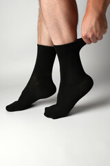 Man putting on a black athletic sock