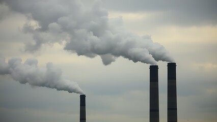 Industrial smokestacks releasing vapor into a cloudy sky, conveying an environmental message with muted tones.