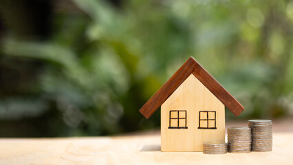 House Model with Stacked Coins Real Estate Investment and Property Finance Concept