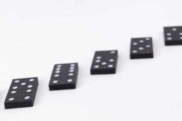 Domino Effect - Black Dominoes in a Row on White Background, Game Pieces.