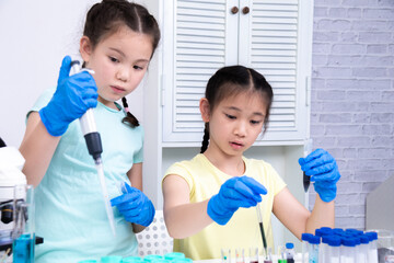 Two students in a science lab perform an experiment with colorful liquids and test tubes. Their expressions show excitement as they explore chemistry in a fun, engaging way, learning, back to school.