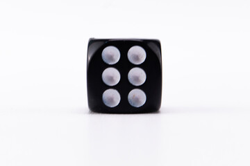 Black Dice Showing Six Dots on White Background, Close-up of Game Piece, Gambling Concept.