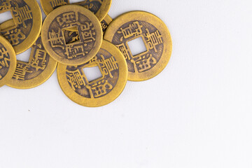 Pile of Antique Chinese Coins with Square Holes on White Background.
