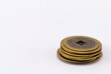 Stack of Antique Chinese Coins with Square Holes on White Background, Close-Up.