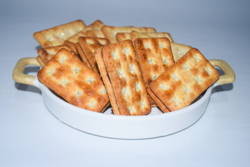 A biscuit is a flour-based baked food item. Biscuits are typically hard, flat, and unleavened. They are usually sweet and may be made with sugar, chocolate, icing, jam, ginger, or cinnamon. 