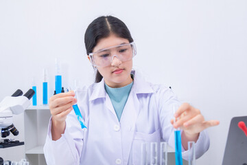 Fototapeta premium Teen girl scientist in labcoat and safety glasses performing chemistry experiment with pipette and test tube in laboratory research setting, focused on precise chemical reaction, healthcare.