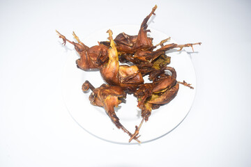 fried quail on a plate with a white background 