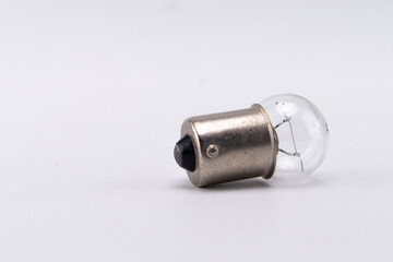 Small Clear Light Bulb with Silver Base on White Background, Close-Up Shot.