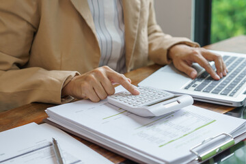 Fototapeta premium Business woman calculating financial statement on calculator&nbsp;income tax online return&nbsp;and payment.